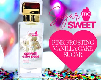 Op de afbeelding: Een heldere parfumfles met een gouden dop en een etiket met confetti cake pops. Het etiket toont "Sugar Me Sweet" en "Pink Frosting Vanilla Cake Sugar". De fles bevat 30 ml biologische parfum.