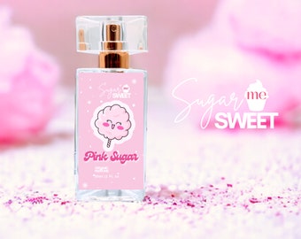 May include: A rectangular perfume bottle with a clear cap and gold-colored sprayer. The label reads "Pink Sugar" with a cartoon cotton candy graphic. The words "Sugar me SWEET" are also visible.