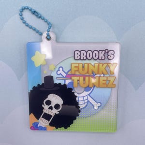 May include: A blue and white keychain with a cartoon skull character and the text "Brook's Funky Tunez".