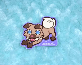 May include: A cartoon sticker of a brown and white dog with blue eyes, a pink tongue sticking out, and the text "PRINTED BY VINYLDISORDER.COM" at the bottom.