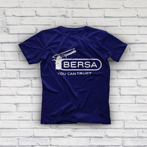 K&ouml;nnte beinhalten: Ein marineblaues T-Shirt mit einer wei&szlig;en Grafik einer Pistole und dem Text "Bersa You Can Trust".