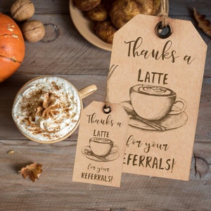 May include: Two brown gift tags with the text "Thanks a Latte for your Referrals!" and a drawing of a latte. The tags are hanging from twine.