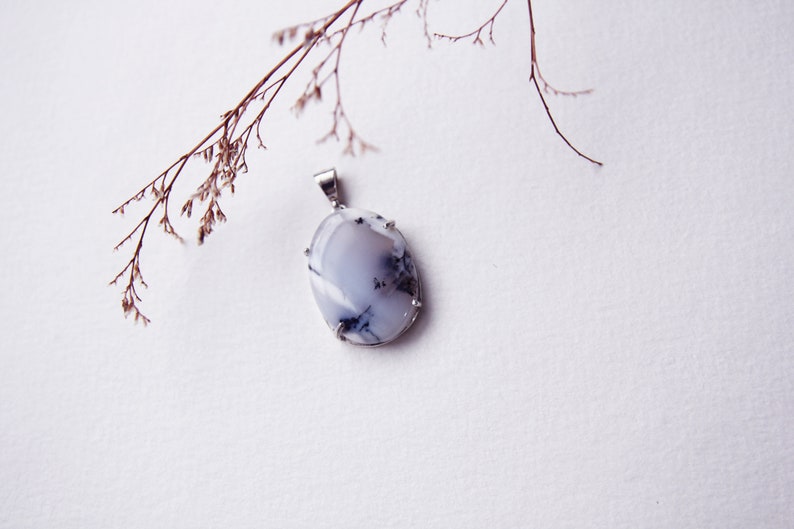 May include: A silver pendant featuring a white and gray oval-shaped gemstone with a silver setting.