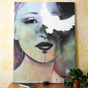 May include: A painting of a woman's face with a white bird flying over her eye. The background is a mix of green, blue, and black.