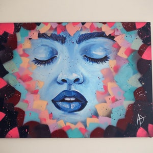 May include: A blue and white painting of a woman's face with closed eyes. The background is a colorful abstract design with pink, blue, and yellow shapes.