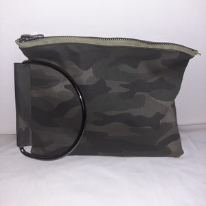 Bolso de mano redondo con asa dorada y diseño de camuflaje