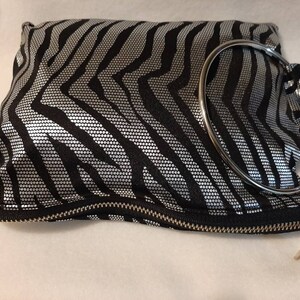 Bolso de mano redondo con lentejuelas y estampado de cebra con asa plateada