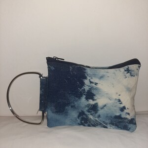 Bolso de mano redondo de mezclilla lavada a la piedra con asa plateada