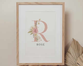 Puede incluir: Una impresión enmarcada con un diseño floral rosa con la letra "R" y el nombre "ROSE" debajo.