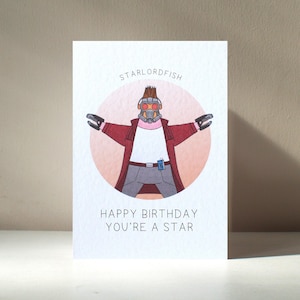 Biglietto d'auguri di compleanno divertente personalizzato "Starlordfish" con personaggio supereroe stella marina illustrato, formato A6 - Benefici di beneficenza