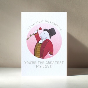 Tarjeta de amor personalizada A6 "El Gran Showmanatee" ilustrada con el manatí, el showman de animales y el aniversario de San Valentín. Beneficia a una organización benéfica.
