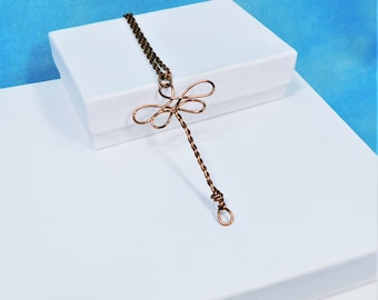 May include: A copper wire dragonfly pendant necklace with a twisted wire chain. The necklace is displayed on a white box.