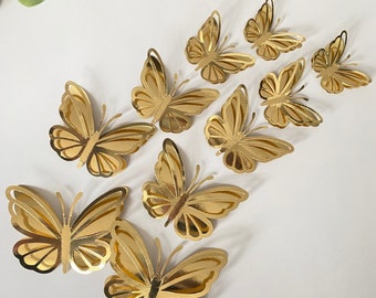 May include: A set of nine gold butterfly wall decor. The butterflies are various sizes and are made of a metallic material.