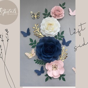 Puede incluir: Un conjunto de decoraci&oacute;n de pared con flores de papel en tonos rosa, blanco y azul, con detalles dorados. Las flores est&aacute;n dispuestas en un racimo con mariposas y vegetaci&oacute;n. El texto "lado izquierdo" est&aacute; escrito en la pared.