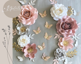 May include: A wall decor set featuring paper flowers in shades of pink, gray, and white, with gold accents. The flowers are arranged in a cluster with butterflies scattered around them. The text "Petals Redefined" is visible in the top left corner.