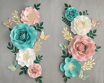 May include: A paper flower arrangement with a variety of colors and styles. The flowers are made of paper and have a 3D effect. The arrangement includes pink, white, and blue flowers with gold accents. There are also butterflies in the arrangement.