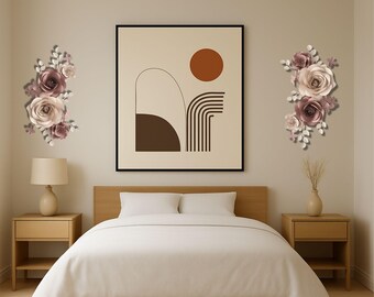 May include: A bedroom scene featuring a bed with a white comforter, flanked by wooden nightstands with lamps. Above the bed is a framed abstract art piece and two floral wall decorations in shades of pink and white.