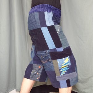 May include: Patchwork denim shorts in various shades of blue, featuring a corduroy waistband and multiple denim patches. The shorts have a pocket with a Levi's tag and a graphic design on the right leg.
