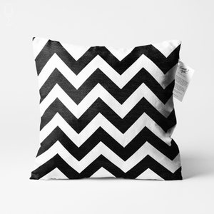 May include: Black and white chevron patterned throw pillow. The pillow is made of a soft, textured fabric.