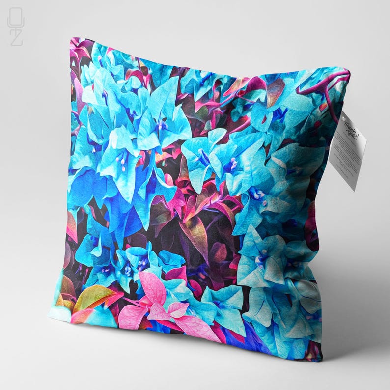 May include: A decorative pillow featuring a vibrant floral pattern with blue and pink flowers on a dark background.