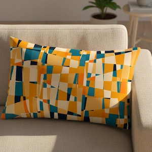 May include: A rectangular cushion with a geometric design in yellow, blue, orange, and white. The cushion is placed on a light beige sofa. The pattern is an abstract design. The cushion adds a splash of colour to the neutral sofa. The cushion is a decorative item.