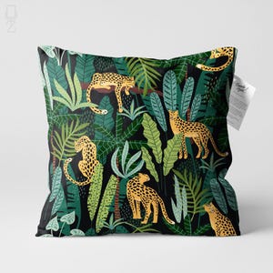 May include: Square cushion with a jungle-themed pattern. The design features multiple cheetahs with yellow and black spots among green tropical foliage on a black background. The cushion has a tag that says "Thank you!"