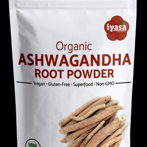 May include: A white resealable pouch with a red label that reads "Organic Ashwagandha Root Powder". The label also states "Vegan Gluten-Free Superfood Non-GMO". The pouch contains a pile of dried ashwagandha root. The USDA Organic seal is visible on the pouch. The pouch has a net weight of 4 oz (113 g).