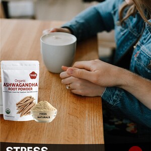 May include: A white mug with a brown liquid inside, a bag of organic Ashwagandha root powder, and the text "Stress Buster" on a wooden table. The bag is labeled "iyasa Naturals" and features a picture of a root. The text "www.iyasaholisitcs.com" is also visible.