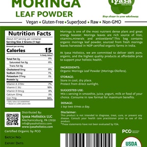 May include: A green and white package of organic moringa leaf powder. The front of the package features the product name "MORINGA LEAF POWDER" in large white letters. The package also includes the brand name "iyasa HOLISTICS" and the text "Vegan. Gluten-Free. Superfood. Raw. Non-GMO". The back of the package includes a nutrition facts label, ingredients, storage instructions, suggested use, dosage, and a disclaimer.
