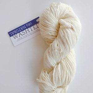 May include: A skein of off-white Washed Natural yarn, labeled "Washed Natural 690" with the text "worsted - approx 100g - 181 yards / 165m - 100% Superwash Merino Wool"