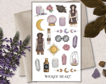 May include: A sheet of stickers with a witchy theme. The stickers feature a woman with long dark hair, a crystal ball, candles, moons, a sun, crystals, and the text "WICKED HEART".