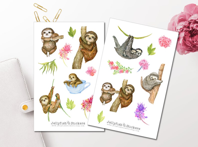 May include: Two sheets of stickers featuring watercolor illustrations of sloths in various poses, including hanging from branches, cuddling, and drinking tea. The stickers also include floral and leafy accents in shades of pink, purple, and green. The text "Jellyfish Stickers" appears on both sheets.