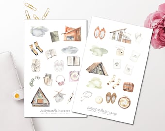 May include: Two sheets of watercolor stickers featuring cozy cabin and home decor illustrations. Designs include houses, socks, books, clouds, and a record player. The text "Jellyfish Stickers" is visible on the bottom of each sheet.