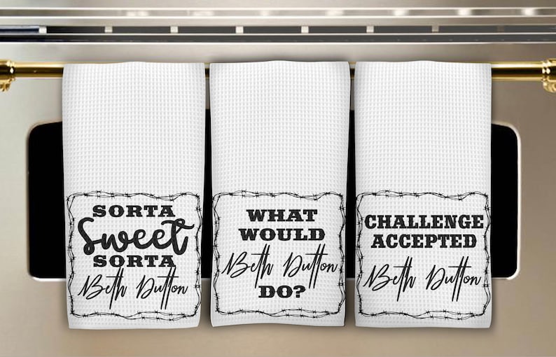 May include: Three white waffle-weave kitchen towels with black text. Each towel has a different phrase: "Sorta Sweet Sorta Beth Dutton", "What Would Beth Dutton Do?", and "Challenge Accepted Beth Dutton".