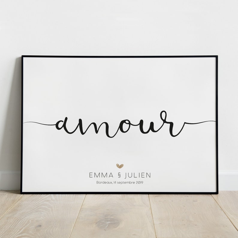 以下が含まれることがあります： 黒い文字で「amour」と書いた白いポスター。文字の下には小さな金色のハートと「Emma & Julien」という名前、そして「Bordeaux, 14 septembre 2019」という日付が書かれている。