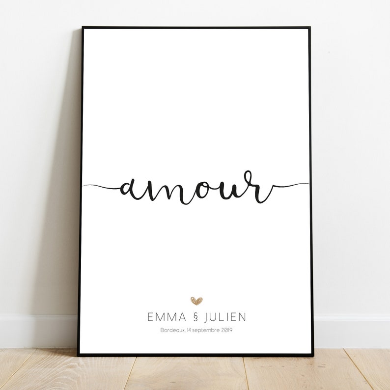 以下が含まれることがあります： 黒い文字で「amour」と書いた白い印刷可能なポスター。テキストの下には、金色のハートマークと「Emma & Julien」という名前、そして「Bordeaux, 14 septembre 2019」という日付が書かれています。