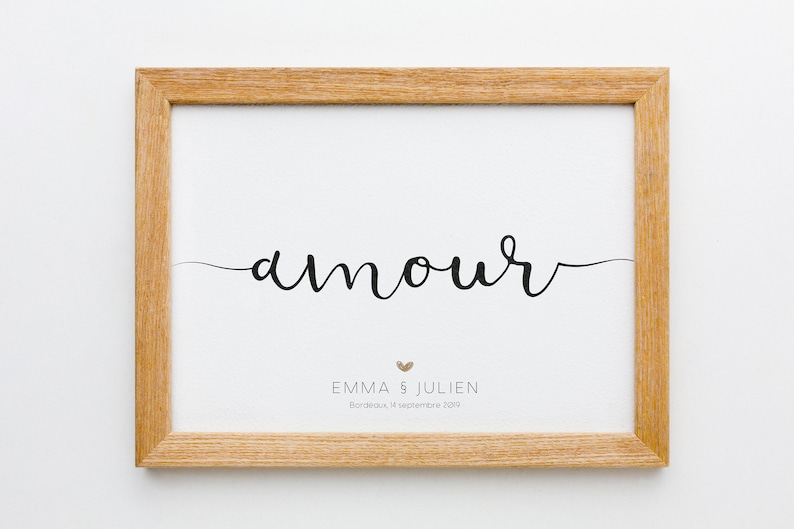 以下が含まれることがあります： 「amour」という単語が筆記体で書かれた額装されたプリント。プリントには「Emma & Julien」という名前と「Bordeaux, 14 septembre 2019」という日付も含まれています。