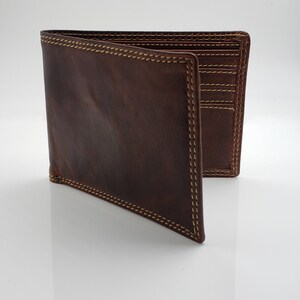 May include: A brown leather wallet with a stitched edge and multiple card slots.