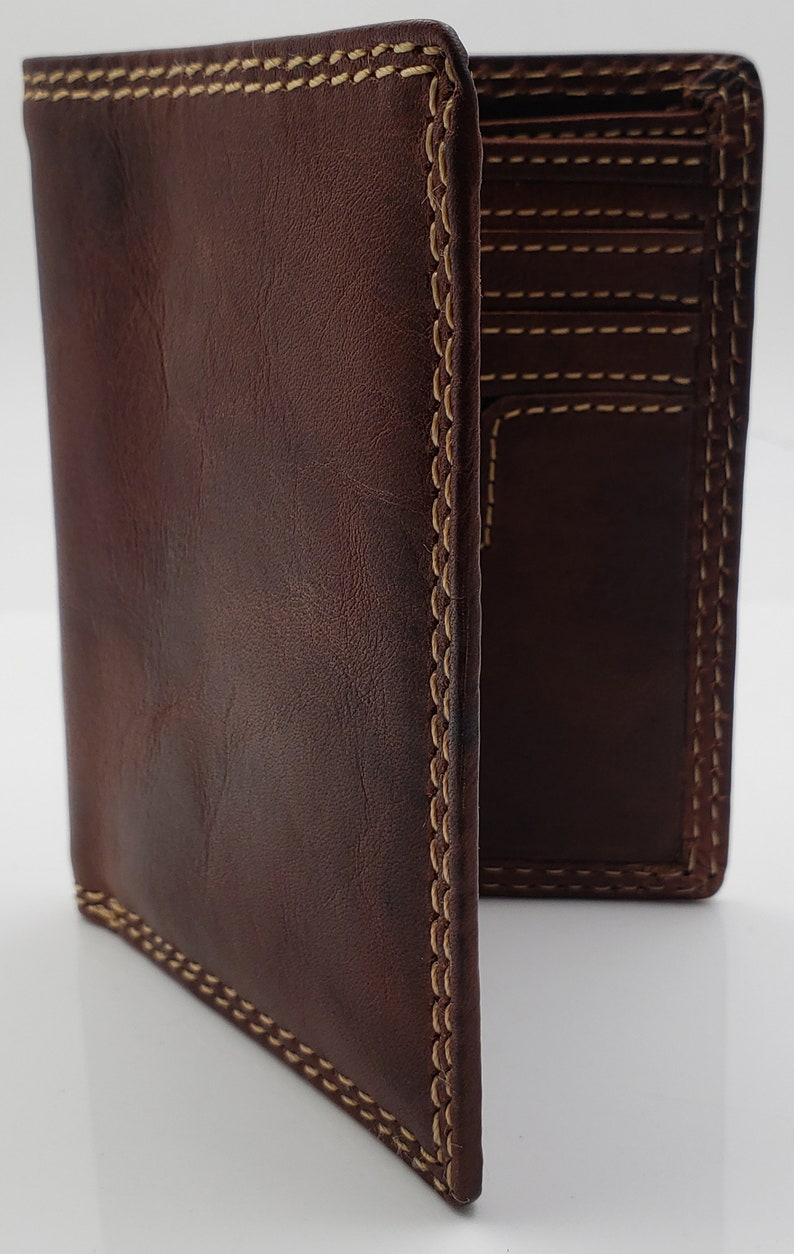 May include: A brown leather wallet with a stitched edge and multiple card slots. The wallet is folded open to show the interior.