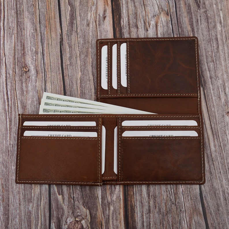 May include: A brown leather wallet with multiple card slots and a billfold. The wallet is open and has several credit cards and cash inside.