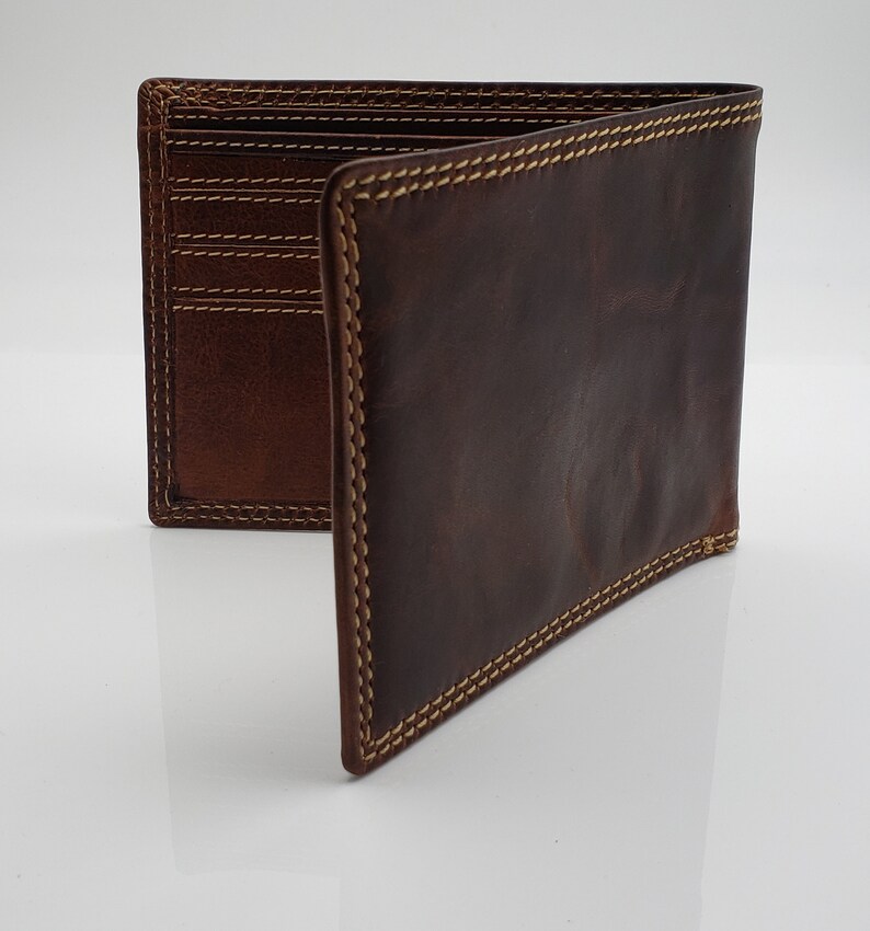 May include: A brown leather wallet with a stitched edge and multiple card slots. The wallet is open and folded in half.