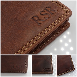 May include: Close-up of a brown leather wallet with a stitched edge. The wallet is personalized with the initials "RSR" in a gold color.