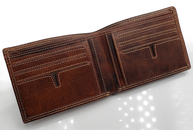 May include: A brown leather wallet with multiple card slots and a billfold. The wallet is open and the interior is visible.