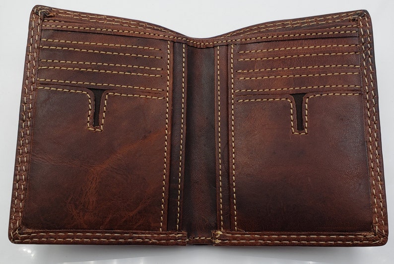 May include: A brown leather wallet with multiple card slots and a billfold. The wallet is open and the interior is visible.