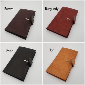 Peut inclure: Quatre portefeuilles en cuir de diff&eacute;rentes couleurs&nbsp;: marron, bordeaux, noir et beige. Chaque portefeuille a une fermeture &agrave; rabat avec deux boutons-pression argent&eacute;s.