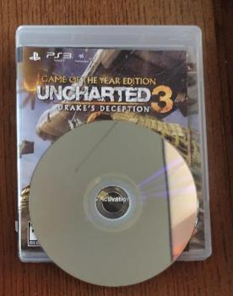 K&ouml;nnte beinhalten: Eine PlayStation 3-Spieledisk f&uuml;r Uncharted 3: Drake's Deception, Game of the Year Edition. Die Disc befindet sich in einem durchsichtigen Plastikcase mit einem schwarzen Etikett.