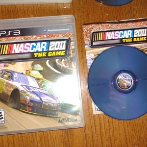 K&ouml;nnte beinhalten: Ein PlayStation 3 Videospiel-Etui f&uuml;r NASCAR 2011: The Game. Das Etui zeigt ein blaues und gelbes Rennfahrzeug auf einer Rennstrecke. Das Spiel ist von der USK mit E f&uuml;r Everyone bewertet.