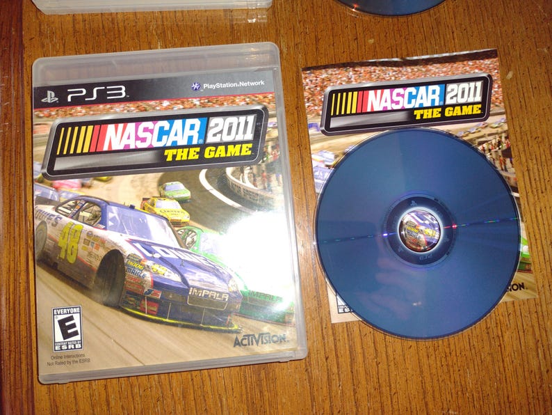 K&ouml;nnte beinhalten: Ein PlayStation 3 Videospiel-Etui f&uuml;r NASCAR 2011: The Game. Das Etui zeigt ein blaues und gelbes Rennfahrzeug auf einer Rennstrecke. Das Spiel ist von der USK mit E f&uuml;r Everyone bewertet.