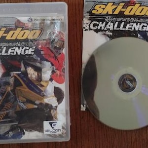K&ouml;nnte beinhalten: Ein PlayStation 3-Spielecase f&uuml;r Ski-Doo Snowmobile Challenge. Das Cover zeigt ein gelbes und schwarzes Schneemobil mit einem Fahrer in einem roten und schwarzen Anzug. Das Spiel ist f&uuml;r alle Altersgruppen freigegeben (E).