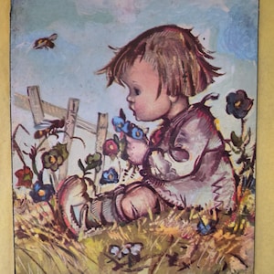 May include: A vintage-style print featuring a child with brown hair sitting in a field of colorful flowers near a wooden fence. A bee flies nearby in the blue sky. The bottom text reads P-210 BUKAC - JUVENILE and LITHO IN U.S.A.